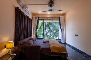 una camera da letto con un letto e una grande finestra di Breezenx a Kīhīm