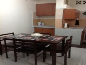 - une table à manger et des chaises dans la cuisine dans l'établissement Nur Muslim 2 Homestay At Kota Bharu, à Kota Bharu