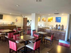 a restaurant with tables and chairs and a bar at Comfort Inn & Suites Phoenix North - Deer Valley in Phoenix