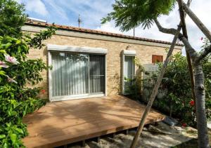 a wooden deck in front of a brick house at Miyakojima Villa Charles in Miyako-jima