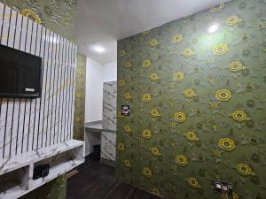 a room with a wall with yellow flowers on it at Green Resort in Rājbāgh