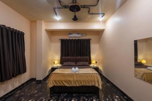 una camera da letto con un letto e un grande specchio di Breezenx a Kīhīm Altre 12 foto