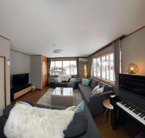 a living room with a couch and a piano at KYŪKA Chalet in Myoko