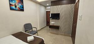 a hotel room with a bed and a chair and a tv at Hotel DC in Bacha