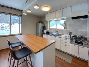 a kitchen with a wooden counter top in a kitchen at KYŪKA Chalet in Myoko