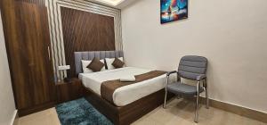 a small bedroom with a bed and a chair at Hotel DC in Bacha