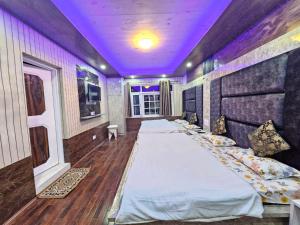 a room with three beds with a purple ceiling at Green Resort in Rājbāgh +10 photos