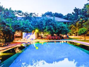a swimming pool with a slide in a yard at Pinthaliya Resort in Sigiriya
