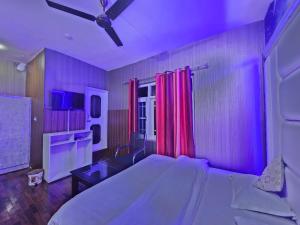 a bedroom with a large bed with a purple light at Green Resort in Rājbāgh