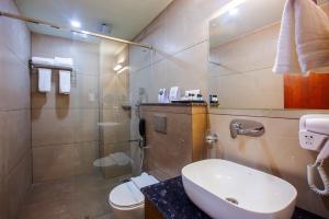 a bathroom with a sink and a toilet and a shower at Hotel Maas Residency in Māvelikara +17 photos