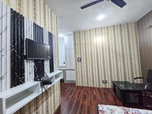 a living room with a tv on a wall at Green Resort in Rājbāgh