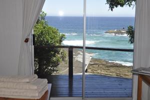 a room with a view of the ocean from a balcony at TussenIn in Eersterivierstrand