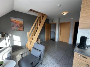 a living room with a staircase and a chair at Möwennest in Norden
