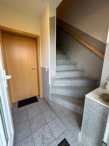 a stairway with a wooden door and a staircase at Möwennest in Norden