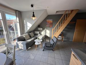 a living room with a couch and a staircase at Möwennest in Norden +7 photos