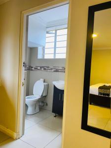 a bathroom with a toilet and a sink at Bayside Hotel 97 Russell Street in Durban