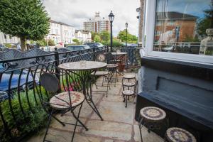 a patio with tables and chairs and a window at The Leicester in Southport