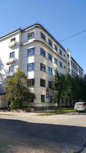 un gran edificio blanco con un coche aparcado delante de él en Bridge Hotel, en Riga