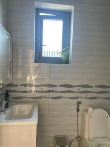 a bathroom with a window and a sink and a toilet at Habi Homestay Doc Let in Phú Thọ +16 photos