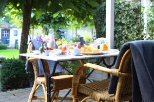 einen Tisch im Freien mit Essen und Obst darauf in der Unterkunft Bed and Breakfast Het Dijkhuis Eersel in Eersel