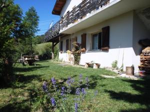 a house with a yard with purple flowers in front of it at Les Elfes in Saint-Jean