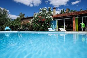 a swimming pool with chairs and a house at La Villa des Violettes in Toulouse
