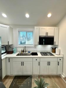 a kitchen with white cabinets and a sink at Modern and Cozy Private Studio in Lynnwood +17 photos