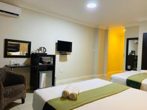 a hotel room with two beds and a tv at Bayside Hotel 97 Russell Street in Durban +17 photos