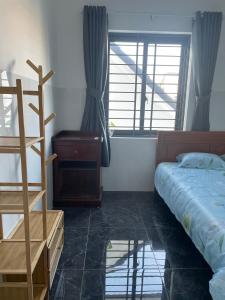 a bedroom with a bed and a dresser and windows at Habi Homestay Doc Let in Phú Thọ