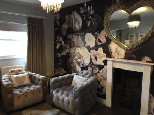 a living room with two chairs and a mirror at The Town House at Brecon in Brecon