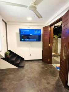 a room with a flat screen tv on the wall at Roo Ceylon Beach Villa in Matara