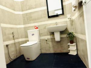 a bathroom with a toilet and a sink at Roo Ceylon Beach Villa in Matara +8 photos