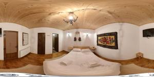 a large room with a bed in the middle of it at Acasa in Maramures in Fereşti