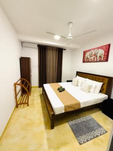 a bedroom with a bed and a chair in it at Roo Ceylon Beach Villa in Matara