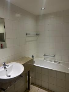 a bathroom with a sink and a bath tub at 312 Mutual Heights Building in Cape Town