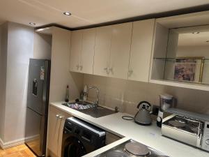 a kitchen with a sink and a dishwasher and a refrigerator at 312 Mutual Heights Building in Cape Town +3 photos