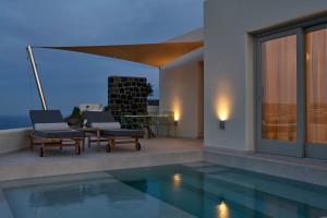 a villa with a swimming pool and a patio at Apanemo Private Suites in Akrotiri
