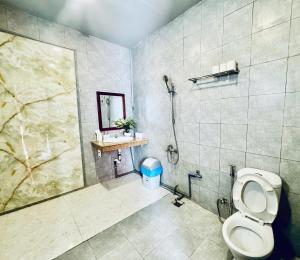 a bathroom with a shower and a toilet and a sink at Emma Bungalow in Phú Quốc
