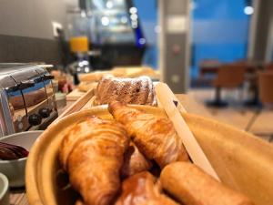 a plate of pastries and bread on a table at Hôtel du Cheval Blanc Brunstatt in Brunstatt +28 photos