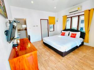 a bedroom with a bed and a flat screen tv at Baan Golden Resort & Residences in Sam Roi Yot