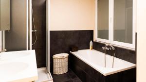 a bathroom with a large tub and a sink at Appartement de Panne zeedijk in De Panne +11 photos