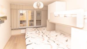 a white room with a bed with a patterned rug at Appartement de Panne zeedijk in De Panne