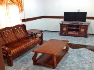 a living room with a couch and a tv at Nur Muslim Homestay At Kota Bharu in Kota Bharu