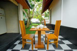 a wooden table and two chairs on a patio at Kurumba Luxury Cabin in Ahangama