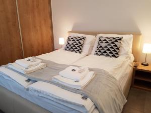 un letto con asciugamani e cuscini sopra di Apartamenty Wierzbowa 5 a Poznań