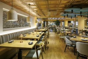 a restaurant with wooden tables and chairs and wine bottles at Hyatt Regency - Greenville in Greenville