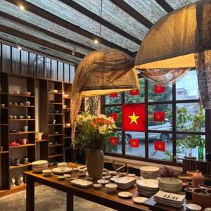 a room with a table with plates and flowers on it at Dreamershomecoffee in Xuan An