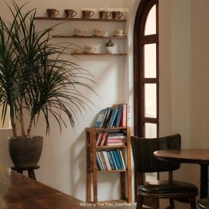 a dining room with a potted plant and a book shelf at Dreamershomecoffee in Xuan An
