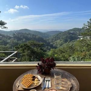 a table with food on it with a view of mountains at Dreamershomecoffee in Xuan An