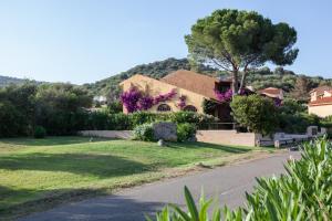 uma casa ao lado de uma estrada em Porto Ottiolu Resort em Porto Ottiolu